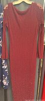 Front view of burgundy metallic rib-knit dress on hanger