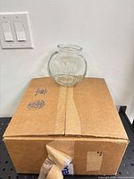 Box with one glass fish bowl on top