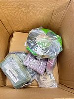 Top view of box showing green tape roll, sage ribbon bundle, lavender streamers, beige ribbon roll and flat box