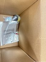 View of box interior with ribbon spool, small bagged items and plastic bag