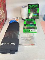 Lot overview showing waist trimmer, neck guards, hockey tape, massage ball, resistance band