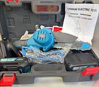 Overall view of mini chainsaw in case with batteries and accessories visible