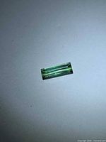 Green baguette-cut tourmaline under diffused light