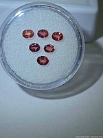 Six oval-cut sapphires in display case