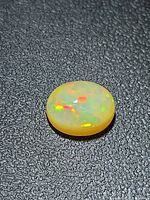Top view showing oval caramel opal with multicolor fire