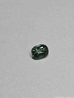 Front view of oval chrome green apatite on neutral background
