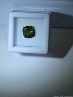 Green cushion-cut sapphire in display box