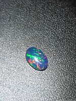 Front view of oval cabochon showing multicoloured play-of-colour