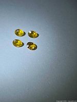 Four oval yellow sapphires top view under light