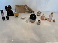 Group shot displaying all perfume bottles, angel figurine, leopard box, Limoges dish and replacement caps