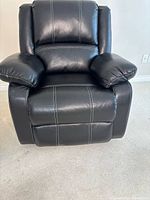 front view of black faux leather recliner showing contrast stitching and overall condition