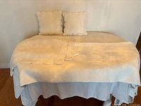 Entire set on bed showing quilt, two pillows, folded shams