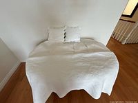 Coverlet draped over bed showing overall size and scalloped edge