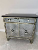 Front view showing mirrored doors, drawer, gold trim