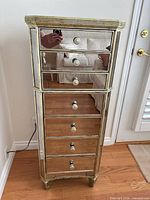 Front view showing entire mirrored tallboy with seven drawers