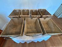 Seven seagrass baskets displayed on table