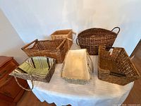Six baskets displayed on table showing overall assortment, shapes and materials
