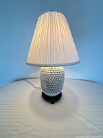 Full view of lamp illuminated, showing shade and base