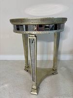 Full view of accent table showing mirrored apron and legs