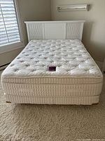 Front view of assembled queen bed showing mattress, box spring and headboard