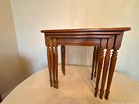Set of three maple nesting tables stacked together showing turned legs