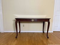 Front view of Queen Anne table showing full structure and cabriole legs
