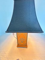 Front view showing painted wood base and black tapered square shade