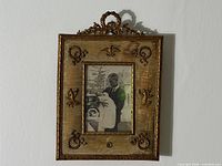 Front view of ornate gilt frame with photo installed