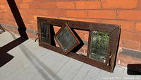 Front view showing entire oak framed mirror coat rack with three mirrors and hooks