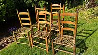 Front angled view of all six ladder back chairs on lawn