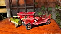 Overall view of lime green truck, red fire truck, red lunch pail on table