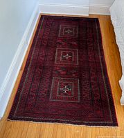 Full view of Baluch wool rug on floor