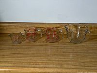 Four graduated Pyrex measuring cups lined up smallest to largest