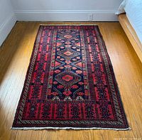 Full view of rug on floor showing overall design and condition