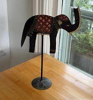 Full view of metal elephant figurine on stand