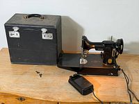 Singer 221 machine on table with case, pedal, keys visible