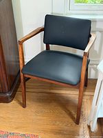 Front angled view of teak armchair showing frame, seat, back