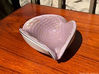 Angled view showing pink interior with gold bullicante bubbles and folded rim