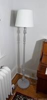 full view of painted grey wood floor lamp with white shade