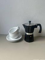 Moka pot with stacked cups and saucers