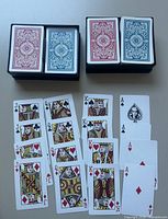 Two open cases showing four decks (two red, two blue) and sample face cards spread out
