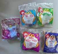Front view of all five sealed Happy Meal toys