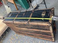 Top view showing overall trunk size, tape measure for length reference, wood slats and metal hardware