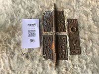 Front view of two Victorian hinges and matching escutcheon plate