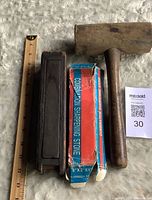 boxed combination stone, cased stone and wooden mallet with ruler for scale