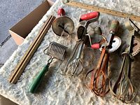 Full lot showing three egg beaters, pastry cutter, dough docker, rulers for scale