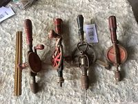 All four vintage hand drills arranged with ruler for scale