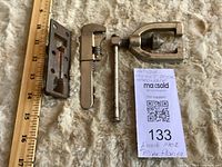 Pocket door latch plate, adjustable wrench, screw clamp, ruler for scale, auction note