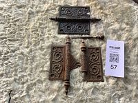 Top view of both ornate cast iron hinges showing pattern, pins and finials