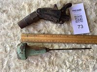 Top view of hose nozzle and awl with ruler for scale
